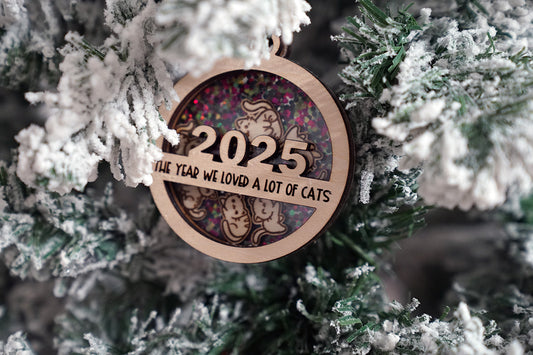 Decorative Christmas ornament with '2025 The Year We Loved a Lot of Cats'